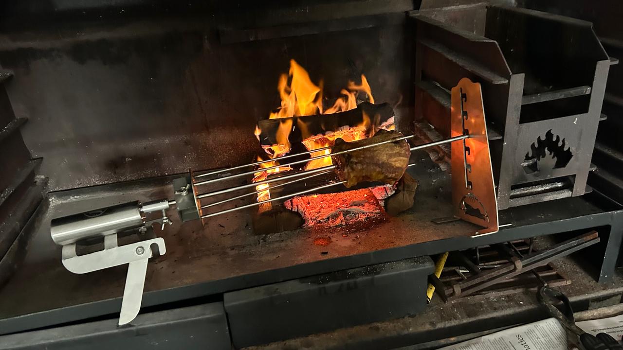 Metal skewer over an open flame in a forge setting